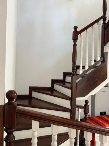 a wooden staircase with white railings in a house at Casa Bunicii Comarnic in Comarnic