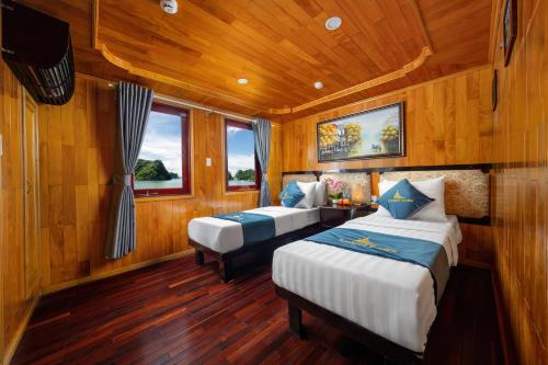 Habitación con 2 camas, paredes de madera y suelo de madera. en Sunlight Boutique Cruise 69, en Cat Ba