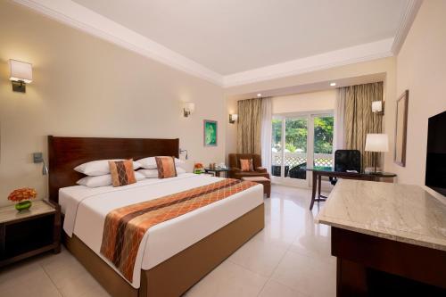 a bedroom with a large bed and a living room at Gateway Aurangabad - Chhatrapati Sambhaji Nagar in Aurangabad
