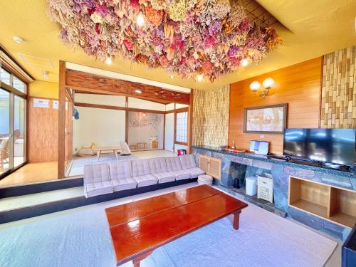a living room with a couch and a flat screen tv at 香川県高松市中心部で駐車6台無料の家族向けゲストハウス in Takamatsu