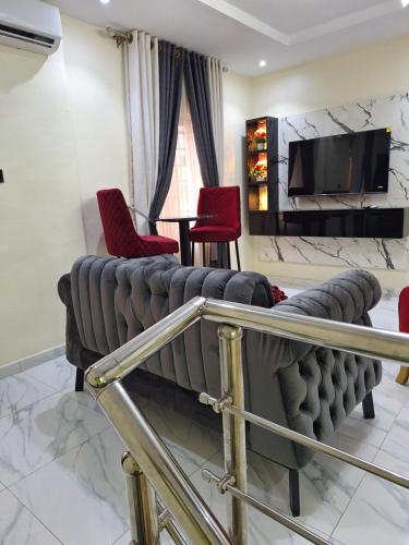 a living room with a couch and red chairs at Royal Beds in Lagos