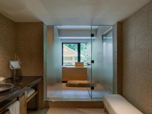 a bathroom with a glass shower and a sink at Banyan Tree Higashiyama Kyoto in Kyoto