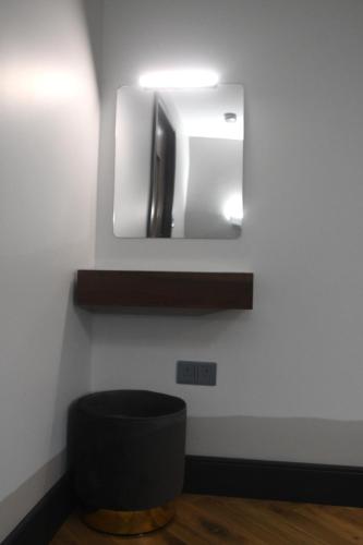 a bathroom with a mirror and a black stool at Luxury Non Smoking 2 bedroom retreat in Norfolk in Attleborough