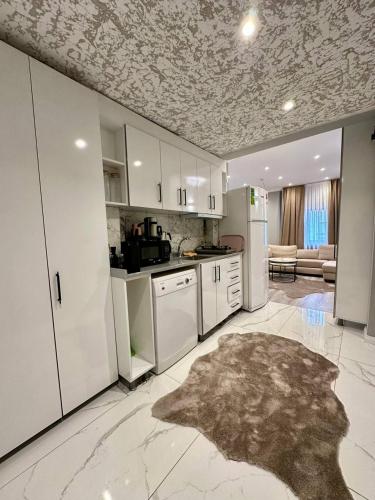 a kitchen with white appliances and a living room at Casa Florya Travel Apartments in Istanbul