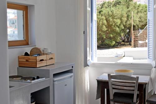 a kitchen with a small table and a window at Thalassa1 in Andros