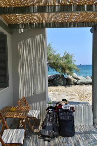 a patio with a table and some bags on the beach at Thalassa1 in Andros