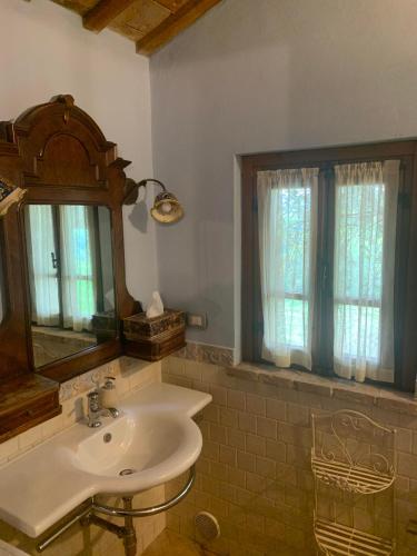 a bathroom with a sink and a mirror and windows at Agriturimo Cà Dorale in Fano