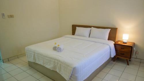 a bedroom with a bed with two candles on it at Hotel pondok putri in Batukaras