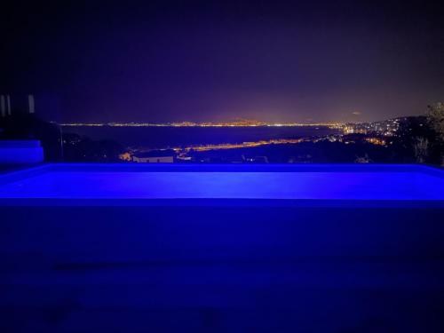 - une piscine ouverte la nuit avec vue sur la ville dans l'établissement Villa vue mer piscine, à Pietrosella