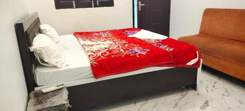 a bed with a red blanket on top of it at Hotel O Home PK Guest Homestay in Ayodhya
