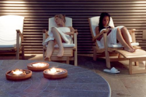 two women sitting in rocking chairs with candles in them at Residence Hotel Serenella in Aprica