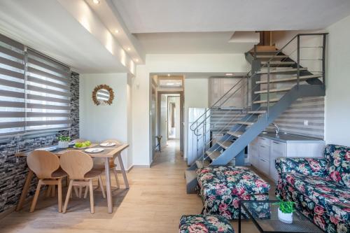 a living room with a staircase and a table and chairs at Apartments Enastron 44 2 bedroom in Pefkochori