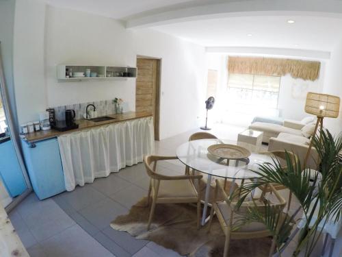ein Wohnzimmer mit Tisch und Küche in der Unterkunft Seminyak Beach Tropical Hideaway Apartment in Seminyak