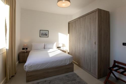 a bedroom with a large bed and a wooden cabinet at Palma Hotel in Port Said
