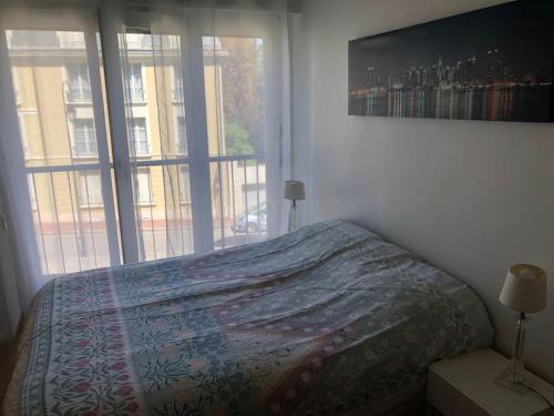 une chambre avec un lit et une grande fenêtre dans l'établissement Nice flat St Germain en Laye centre 30 minutes to Paris, à Saint-Germain-en-Laye