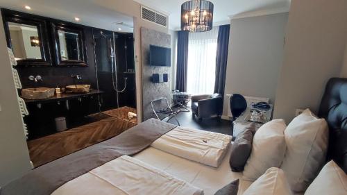 a bedroom with a large bed and a bathroom at Villahotel Rheinblick in Cologne