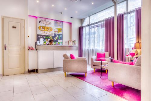 a living room with pink furniture and windows at Pink Hotel in Paris