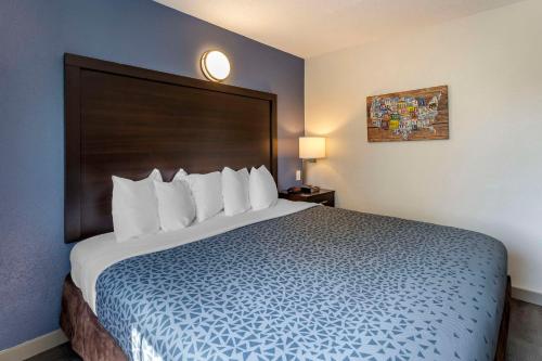 a bedroom with a large bed with a large headboard at Greenville Pelham Inn by IHG in Greenville