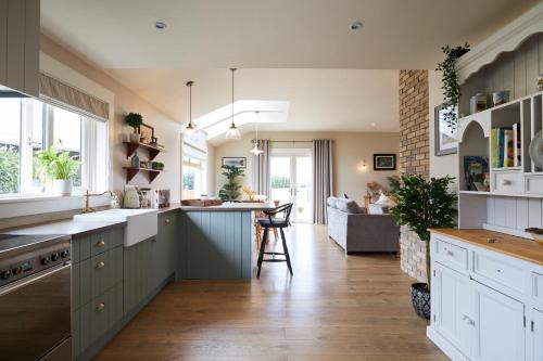 a kitchen with white cabinets and a table in it at The Lake Lodge in Killaloe