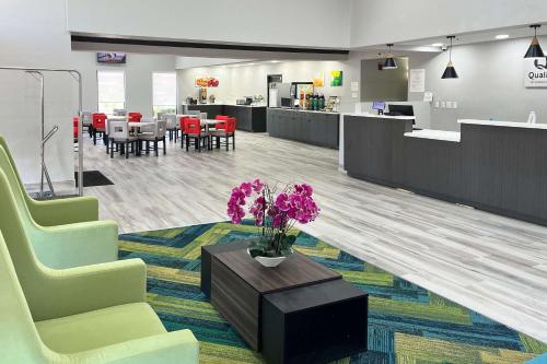 a lobby with chairs and a table with purple flowers at Quality Inn & Suites at Airport Blvd I-65 in Mobile