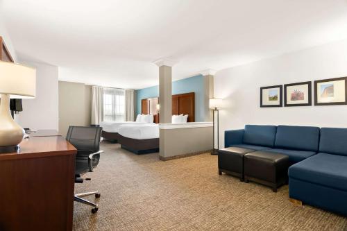 a hotel room with a couch and a bed at Comfort Suites Rensselaer near Fair Oaks in Rensselaer