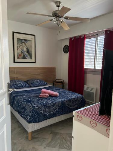 une chambre avec deux lits et un ventilateur de plafond dans l'établissement Chambre confortable chez l'habitant, à Toulon