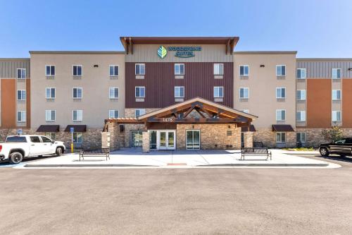 a hotel with benches in front of a parking lot at WoodSpring Suites Bluffdale Salt Lake City in Bluffdale