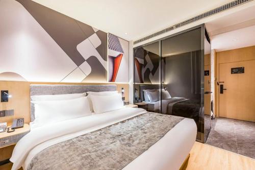 a bedroom with a large white bed in a room at Feifan Chengpin Hotel Beijing Tongzhou Orchard Global Resort Branch in Tongzhou
