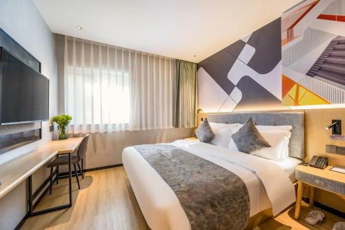 a hotel room with a large bed and a desk at Feifan Chengpin Hotel Beijing Tongzhou Orchard Global Resort Branch in Tongzhou