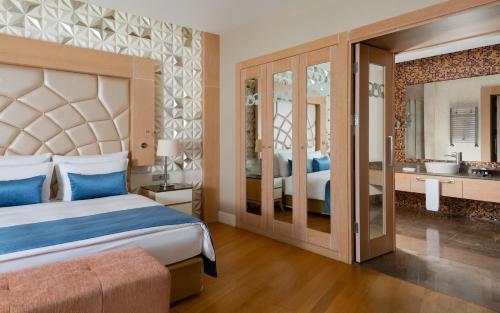 a bedroom with a king sized bed and a bathroom at Badamdar Hotel and Residences in Baku