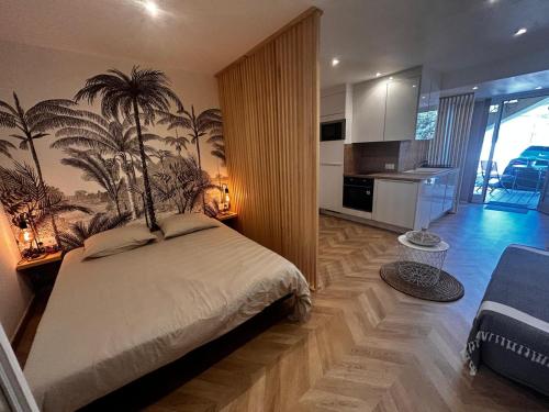 - une chambre avec un lit orné d'une fresque murale de palmiers dans l'établissement Studio moderne climatisé avec coin nuit, proche mer et Hauts de Cagnes, à Cagnes-sur-Mer