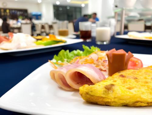 a white plate with a sandwich and salad on a table at Khách sạn Thái Bình Dream in Thái Bình