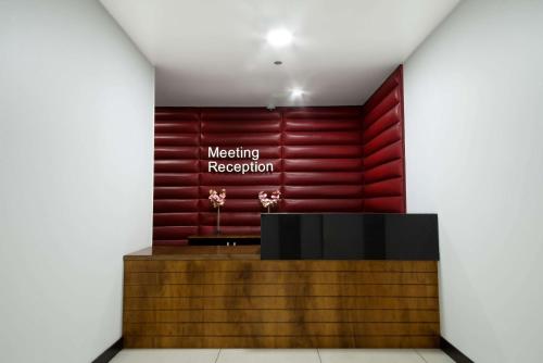 une salle de réunion avec un panneau sur un mur rouge dans l'établissement D Sabana Hotel San José, à San José