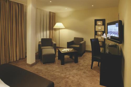 a hotel room with a living area with chairs and a television at Hotel & SPA Waldecker Hof in Willingen