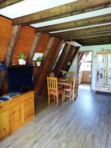 a living room with a table and a tv at Ferienhaus Meister Eder in Waldkirchen