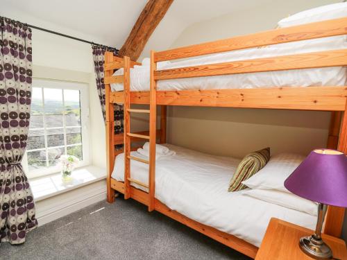 a bunk bed room with two bunk beds and a window at Penuwch Fach in Llanfihangel-y-creuddyn