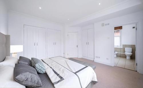 a white bedroom with a bed and a bathroom at Wonderful House Central London - Westminster in London