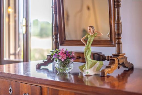 a statue of a woman sitting on a table with a vase of flowers at Agriturimo Cà Dorale in Fano