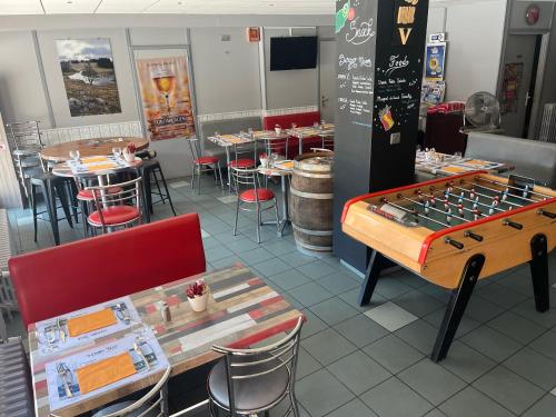 un restaurant avec un baby-foot, des tables et des chaises dans l'établissement Urbain V, à Le Monastier