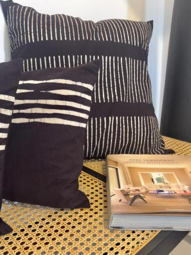 a bed with pillows and a book on a table at Villa Vikasa Colombo in Colombo