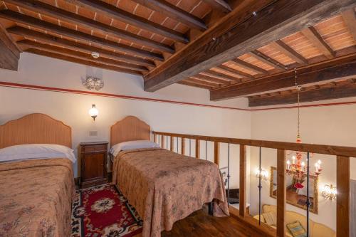 two beds in a room with wooden ceilings at Hotel San Michele in Cortona