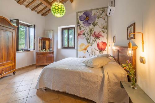 a bedroom with a bed with a flower mural on the wall at Agriturimo Cà Dorale in Fano