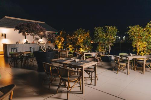 a restaurant with tables and chairs on a patio at night at Palma Hotel in Port Said