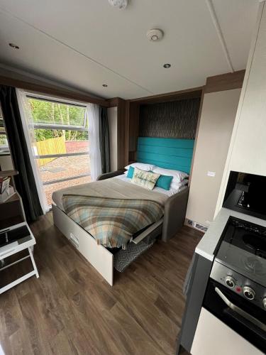 a bedroom with a bed and a stove at Ravenswood Pod in Fort William