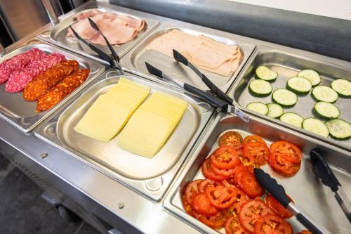 a buffet table with cheese and other food items at Urbany Hostel BCN GO! in Barcelona
