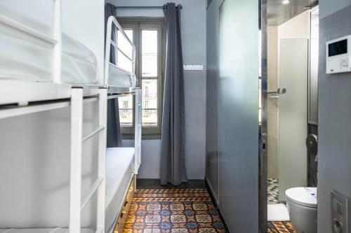 a small room with a bunk bed and a toilet at Urbany Hostel BCN GO! in Barcelona