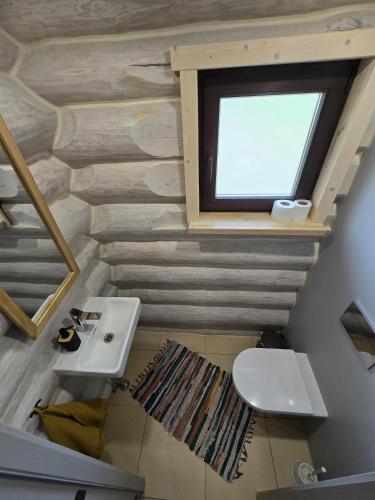 a bathroom with a white toilet and a window at PUTNI Resort in Laukbeitini
