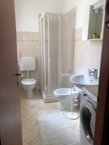 a bathroom with a toilet and a sink and a washing machine at Casa Seggiovia in Frabosa Soprana