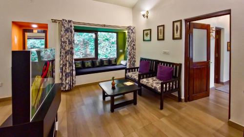 a living room with a couch and a table at Tathastu Kanha in Kānha