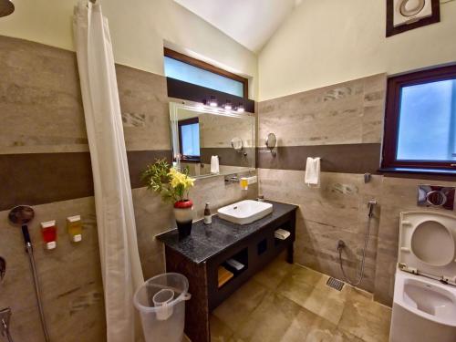 a bathroom with a sink and a mirror at Tathastu Kanha in Kānha